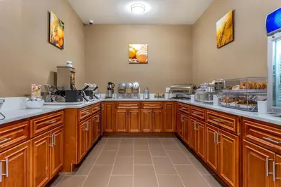 a large kitchen with wooden cabinets and aasteryasteryasteryasteryasteryasteryasteryastery at Comfort Inn Brewster in Brewster
