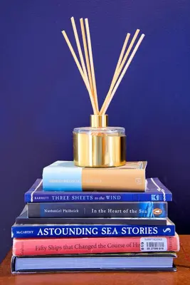 a stack of books with a gold container on top at Nautical Nest Hudson in Hudson