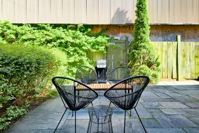 a patio with three chairs and a table in a yard at Nautical Nest Hudson in Hudson