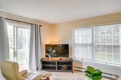 a living room with a tv and two windows at Cozy Catskill Condo - 2 Mi to Windham Mountain Ski in Windham