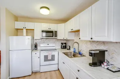 a kitchen with white appliances and white cabinets at Cozy Catskill Condo - 2 Mi to Windham Mountain Ski in Windham