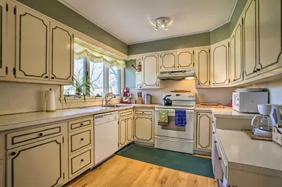 a kitchen with white cabinets and white appliances at Historic House with Record Player, Walk to Downtown! in Roxbury