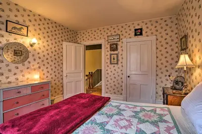 a bedroom with a bed and a dresser with a red blanket at Historic House with Record Player, Walk to Downtown! in Roxbury
