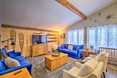 a living room with blue couches and a tv at Woodsy Wilmington Condo 7 Mi to Mount Snow! in Wilmington