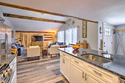 a kitchen with a sink and a living room at Woodsy Wilmington Condo 7 Mi to Mount Snow! in Wilmington