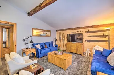 a living room with blue couches and a tv at Woodsy Wilmington Condo 7 Mi to Mount Snow! in Wilmington