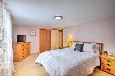 a bedroom with a bed and a dresser and a television at Woodsy Wilmington Condo 7 Mi to Mount Snow! in Wilmington