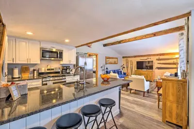 a kitchen with white cabinets and bar stools at Woodsy Wilmington Condo 7 Mi to Mount Snow! in Wilmington