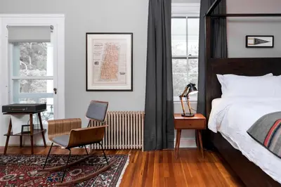 a bedroom with a bed and a chair and a desk at Granville House in Great Barrington