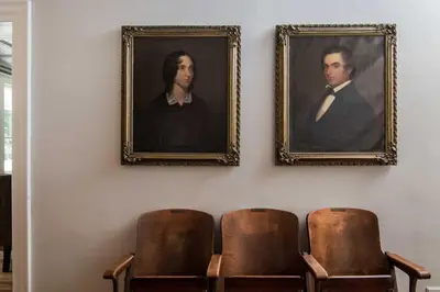 two portraits of a man and a woman on a wall at Granville House in Great Barrington
