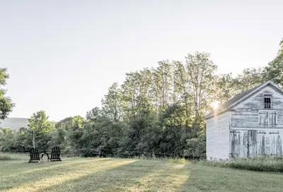 an old house and a bench in a field at Granville House in Great Barrington