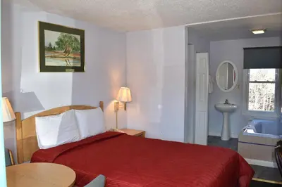 a hotel room with a red bed and a sink at POCONO NIGHT LODGE in Bartonsville
