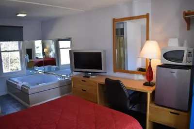 a bathroom with a tub and a television and a television at POCONO NIGHT LODGE in Bartonsville