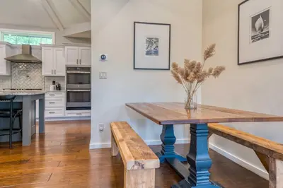 a kitchen with a wooden table and benches at The Mountain House Windham Retreat with Hot Tub! in Windham