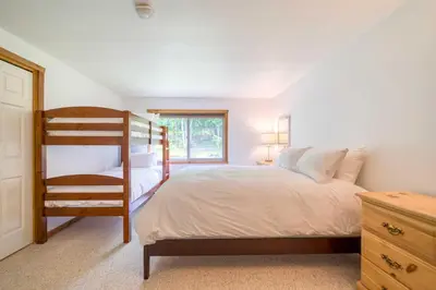 a bedroom with a bunk bed and a chair at The Mountain House Windham Retreat with Hot Tub! in Windham