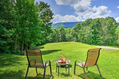 two chairs and a fire pit in the grass at The Mountain House Windham Retreat with Hot Tub! in Windham