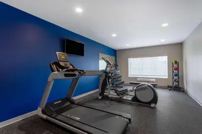 a gym with blue walls and a treadmill at Microtel Inn & Suites by Wyndham Amsterdam NY in Amsterdam