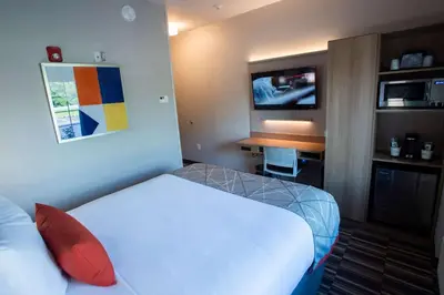 a hotel room with a bed and a television at Microtel Inn & Suites by Wyndham Amsterdam NY in Amsterdam