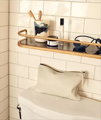 a white bathroom with a shelf above a toilet at The Hoxton, Williamsburg in Brooklyn