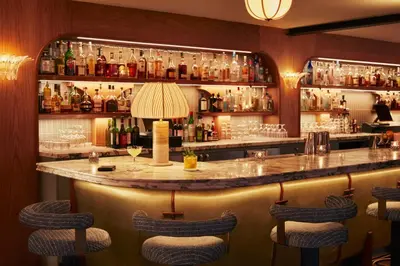 a bar with a marble counter and stools at The Hoxton, Williamsburg in Brooklyn