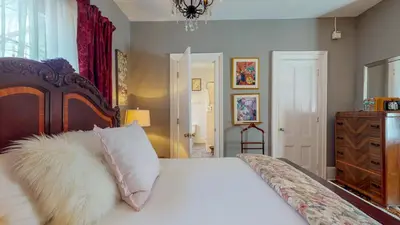a bedroom with a white bed with a wooden headboard at Gardner Farm Inn in Troy