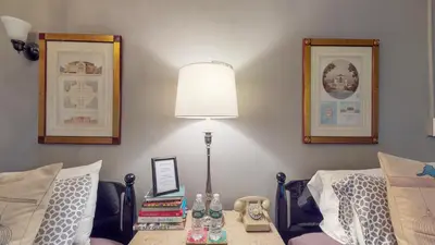 a lamp sitting on a table next to a bed at Gardner Farm Inn in Troy