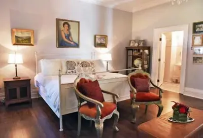 a bedroom with a bed and two chairs and a table at Gardner Farm Inn in Troy