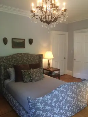 a bedroom with a bed and a chandelier at Gardner Farm Inn in Troy