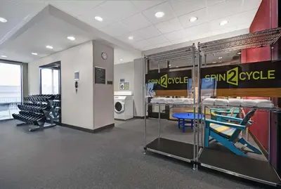 a room with two bunk beds and a table and chairs at Home2 Suites By Hilton Utica, Ny in Utica