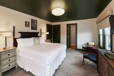 a bedroom with a large white bed and a desk at The Whitlock by The Lenox Collection in Lenox