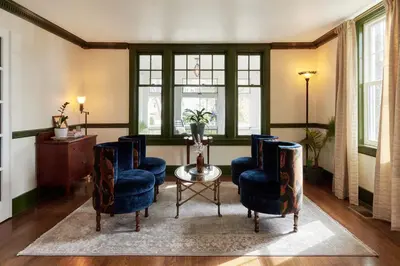 a living room with chairs and a table and windows at The Whitlock by The Lenox Collection in Lenox