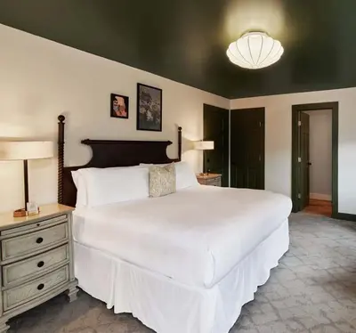 a bedroom with a large white bed and a lamp at The Whitlock by The Lenox Collection in Lenox