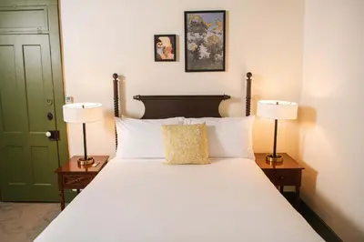 a large white bed with two lamps and a green door at The Whitlock by The Lenox Collection in Lenox