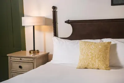 a bed with a pillow and a lamp on a night stand at The Whitlock by The Lenox Collection in Lenox