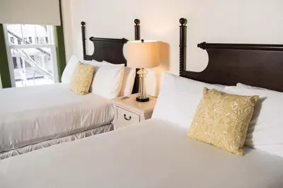 a bedroom with two beds and a lamp on a night stand at The Whitlock by The Lenox Collection in Lenox