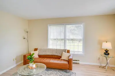a living room with a couch and a glass table at Peaceful Catskills Condo with Deck and Mountain View! in Windham