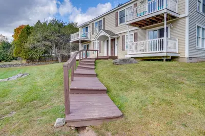 a wooden walkway in front of a house at Peaceful Catskills Condo with Deck and Mountain View! in Windham