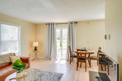 a living room with a couch and a table at Peaceful Catskills Condo with Deck and Mountain View! in Windham