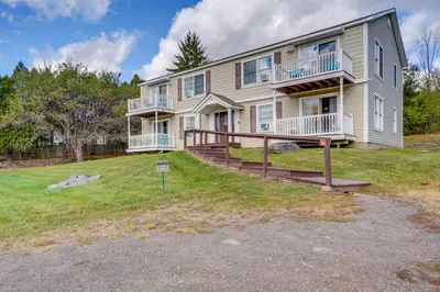 a large house with a large yard in front of it at Peaceful Catskills Condo with Deck and Mountain View! in Windham