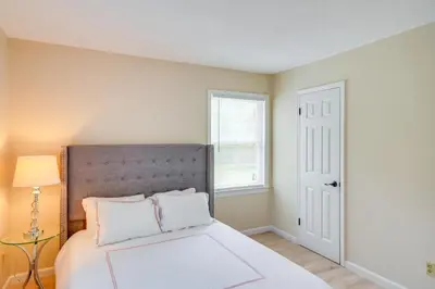 a bedroom with a white bed and a window at Peaceful Catskills Condo with Deck and Mountain View! in Windham