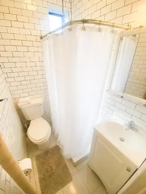 a white bathroom with a toilet and a sink at 2 Bedrooms Entire Beautiful Apt in Williamsburg! in Brooklyn