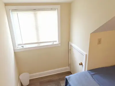 a small bedroom with a window and a bed at 1950s Charm In The Heart Of Waterbury in Waterbury