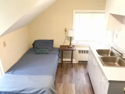 a small room with a bed and a sink at 1950s Charm In The Heart Of Waterbury in Waterbury