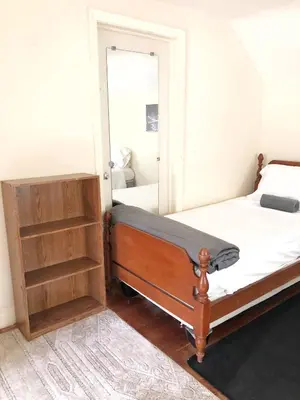 a bedroom with a bed and a mirror at 1950s Charm In The Heart Of Waterbury in Waterbury