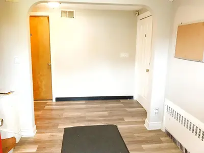 a hallway with a door and a rug on the floor at 1950s Charm In The Heart Of Waterbury in Waterbury