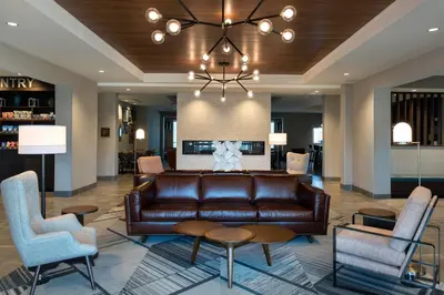 a living room with a leather couch and chairs at Four Points by Sheraton Albany in Albany