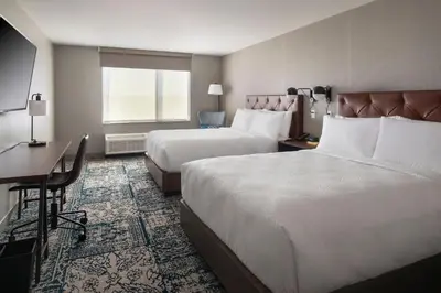 a hotel room with two beds and a desk at Four Points by Sheraton Albany in Albany