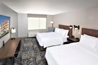 a hotel room with two beds and a desk at Four Points by Sheraton Albany in Albany