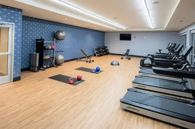 a gym with exercise equipment and balls on the floor at Four Points by Sheraton Albany in Albany