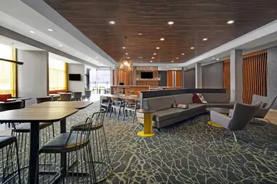a hotel lobby with a couch and tables and chairs at SpringHill Suites by Marriott Hartford Cromwell in Cromwell